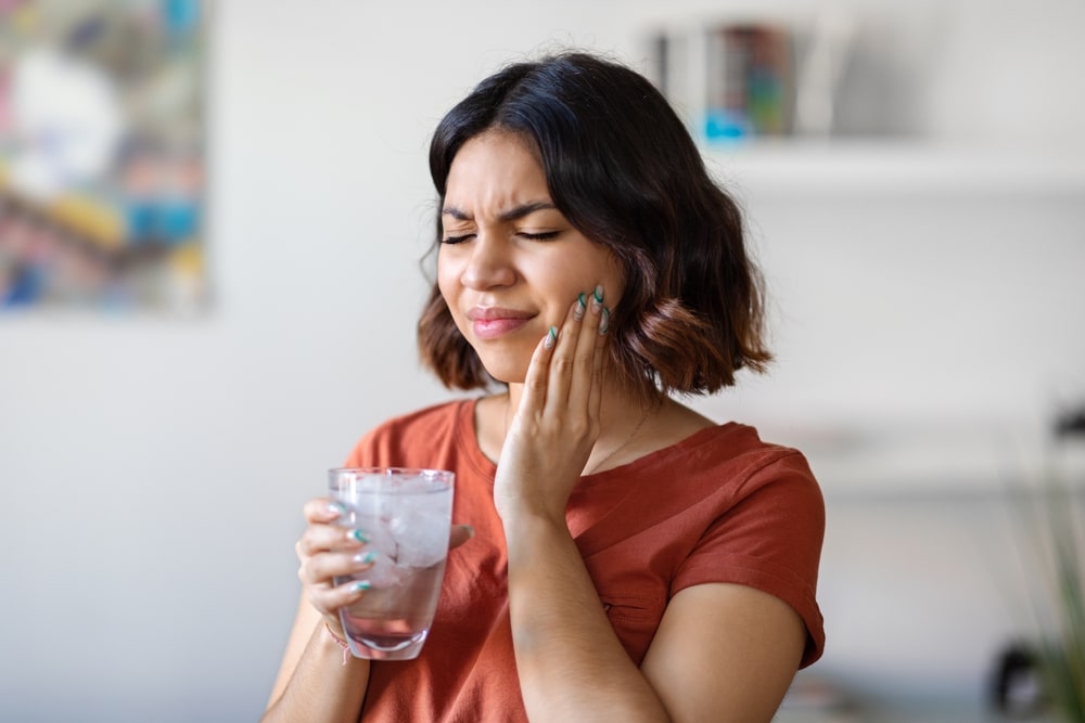 Une jeune femme souffre d'hypersensibilité dentinaire
