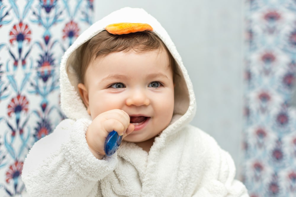 Un bébé tient une brosse à dents dans sa bouche