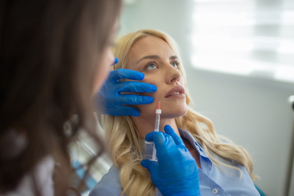 Une femme se fait injecter du Botox près de la mâchoire