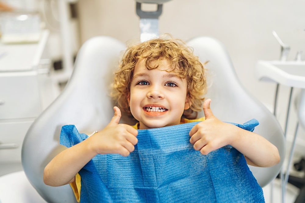 Un jeune enfant est heureux lors de son rendez-vous chez le dentiste